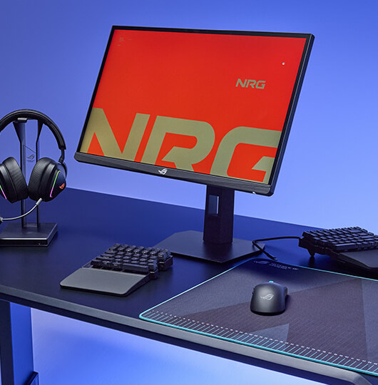 tabletop with a full PC setup, showcasing the ROG Falcata, ROG Harpe II Ace and the monitor inscreeen showing the NRG logo design.