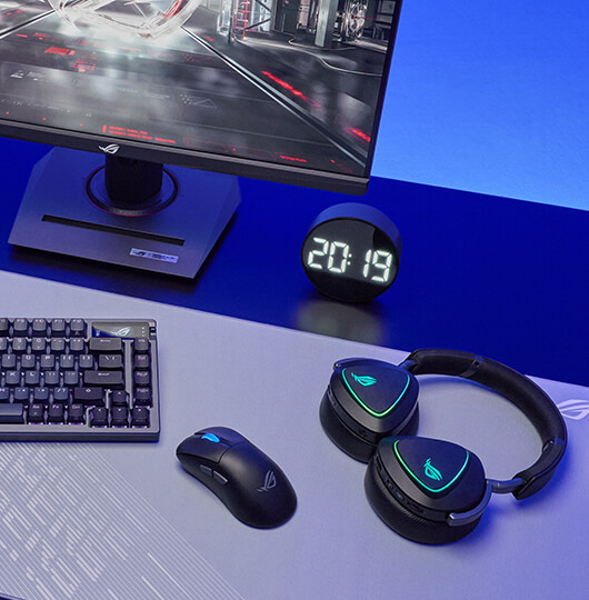 A tabletop with a keyboard, mouse, headset and a monitor on the side