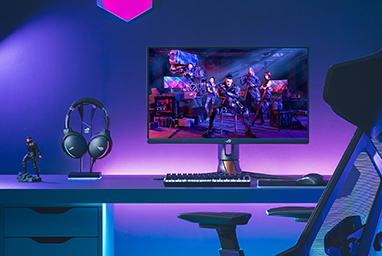 the ROG esports gaming monitor within a complete gaming setup with blue and purple backliight coming from behind