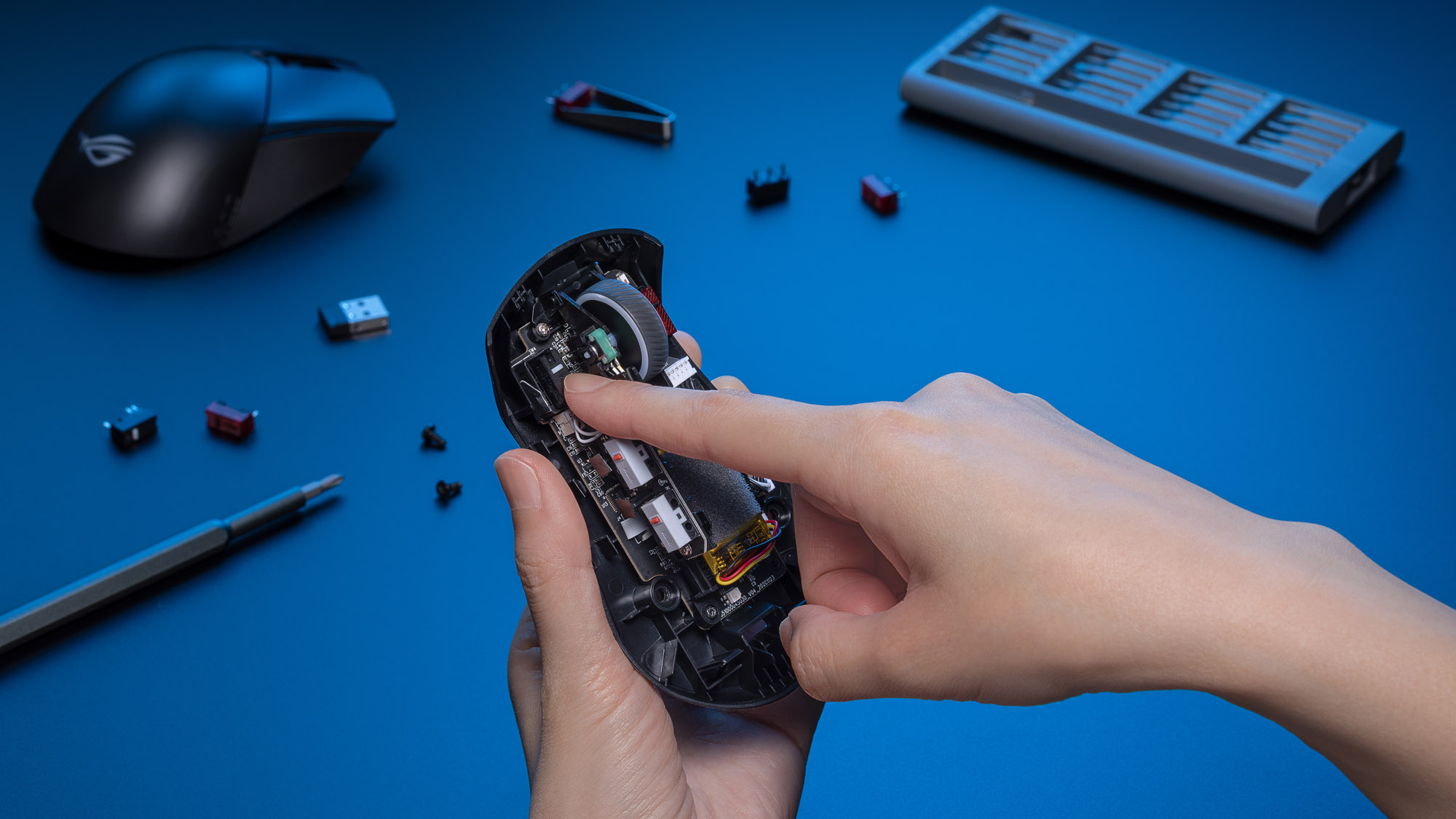 A photo showing a hand pressing a new mouse switch into place.