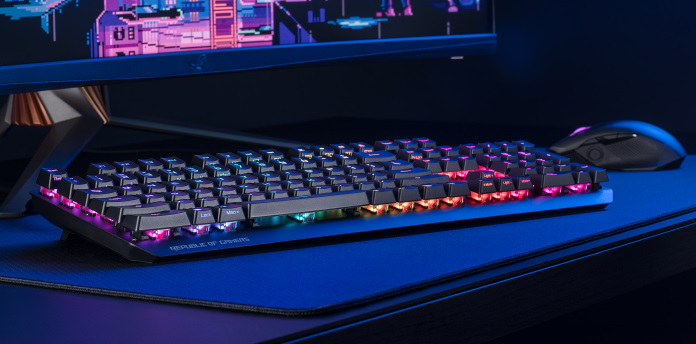 ROG Strix Scope RX-Tastatur auf einem Schreibtisch mit einem Monitor und der ROG Chakram-Maus