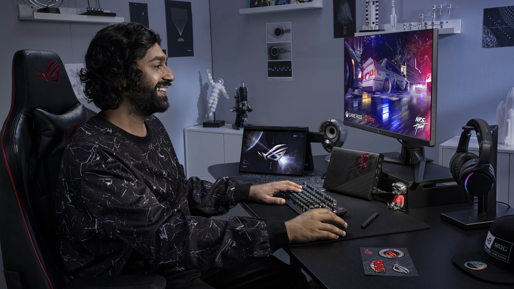 A man playing games at his desk with an external monitor, keyboard, and mouse with the ROG Flow X13 hooked up to the XG Mobile external graphics card.