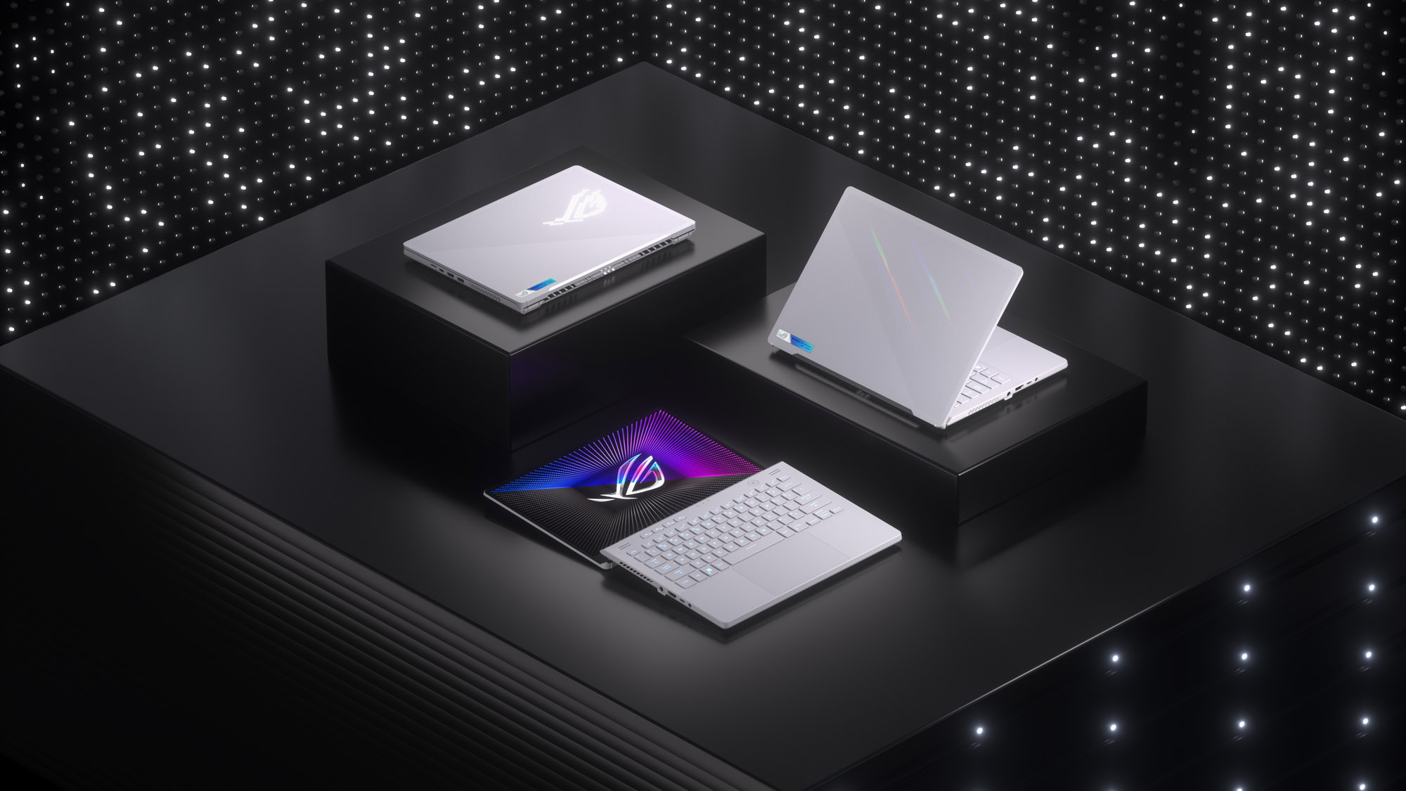 Three Moonlight White ROG Zephyrus G14’s, arranged on three pillars of differing heights, with the lid closed, half opened, and fully opened. 