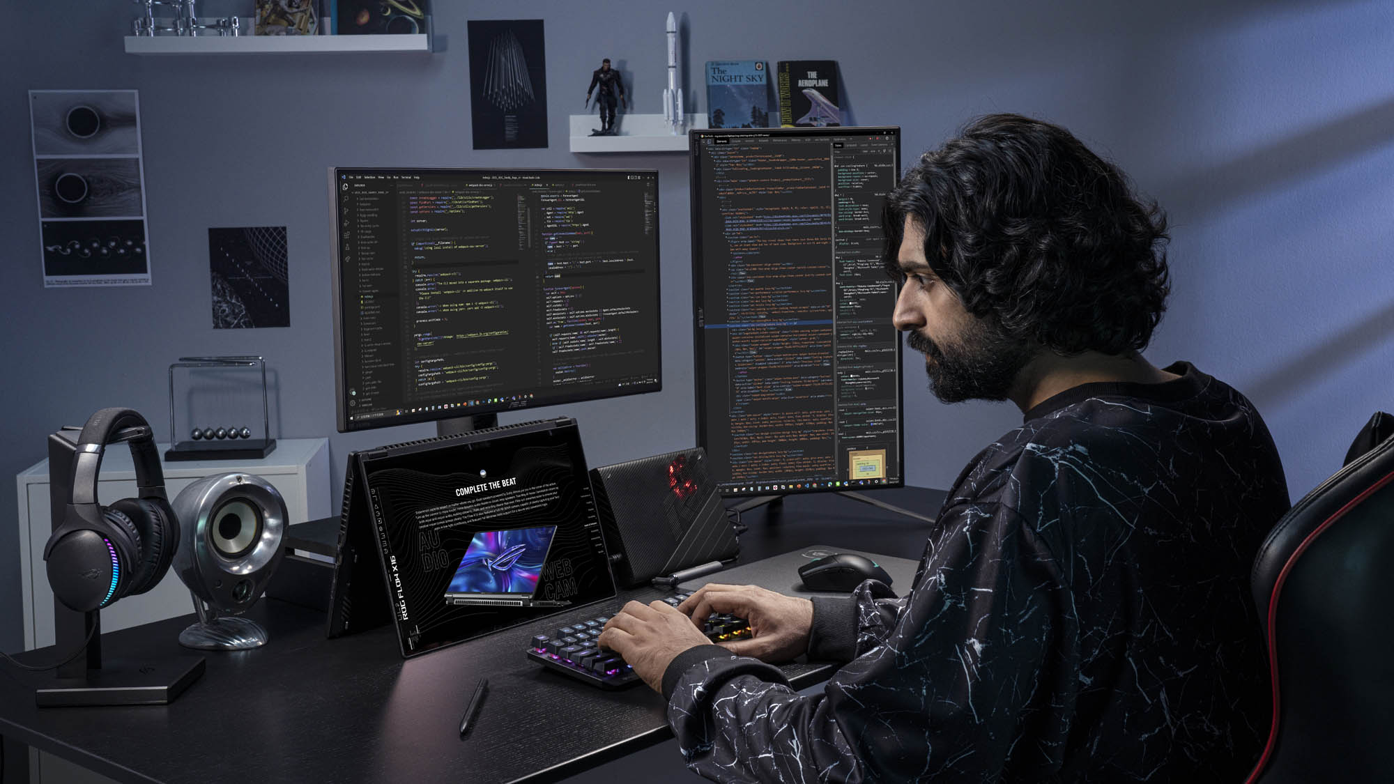 A man writing code on a dual-monitor setup with the ROG Flow X16 in tent mode, hooked up to an XG Mobile external graphics card.