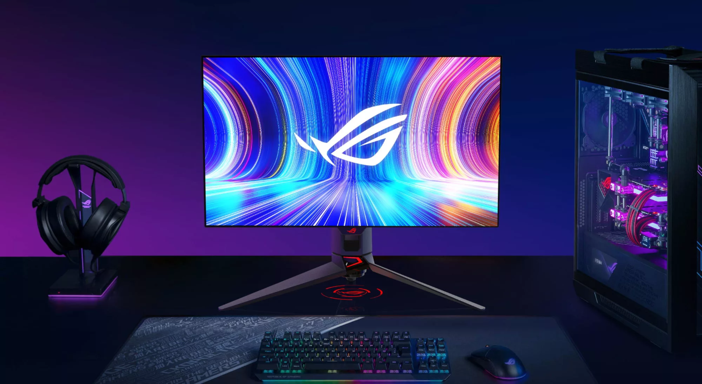Der ROG Swift OLED PG27AQDM Monitor auf einem Schreibtisch mit einer Tastatur, einem Headset und einem Desktop-PC.