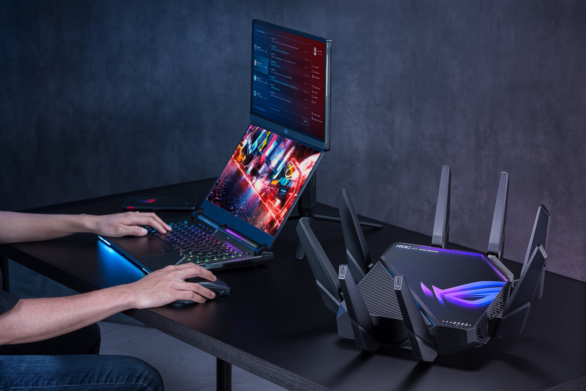 The ROG Rapture GT-AXE16000 wireless router on a desk with other ROG gaming gear