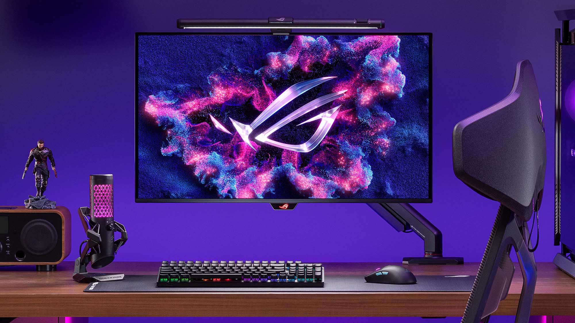 The ROG Swift OLED PG32UCMP on a desk with the ROG Aura Monitor Light Bar affixed on top.