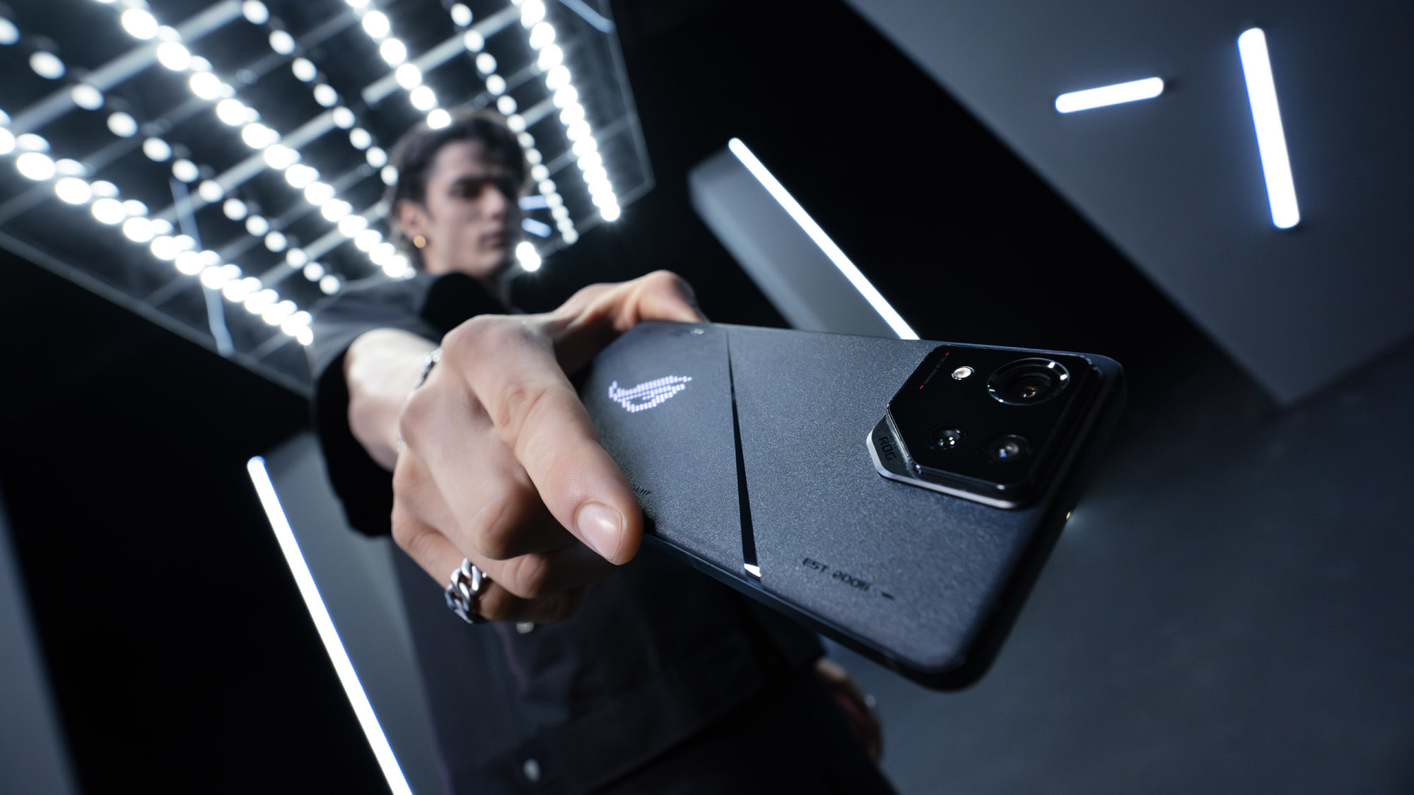 A low-angle shot of a man holding the ROG Phone 8 Pro.