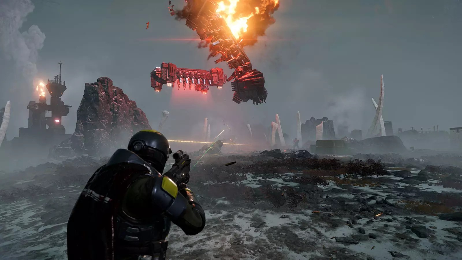 An armored soldier pointing a gun at an exploding ship falling from the sky.