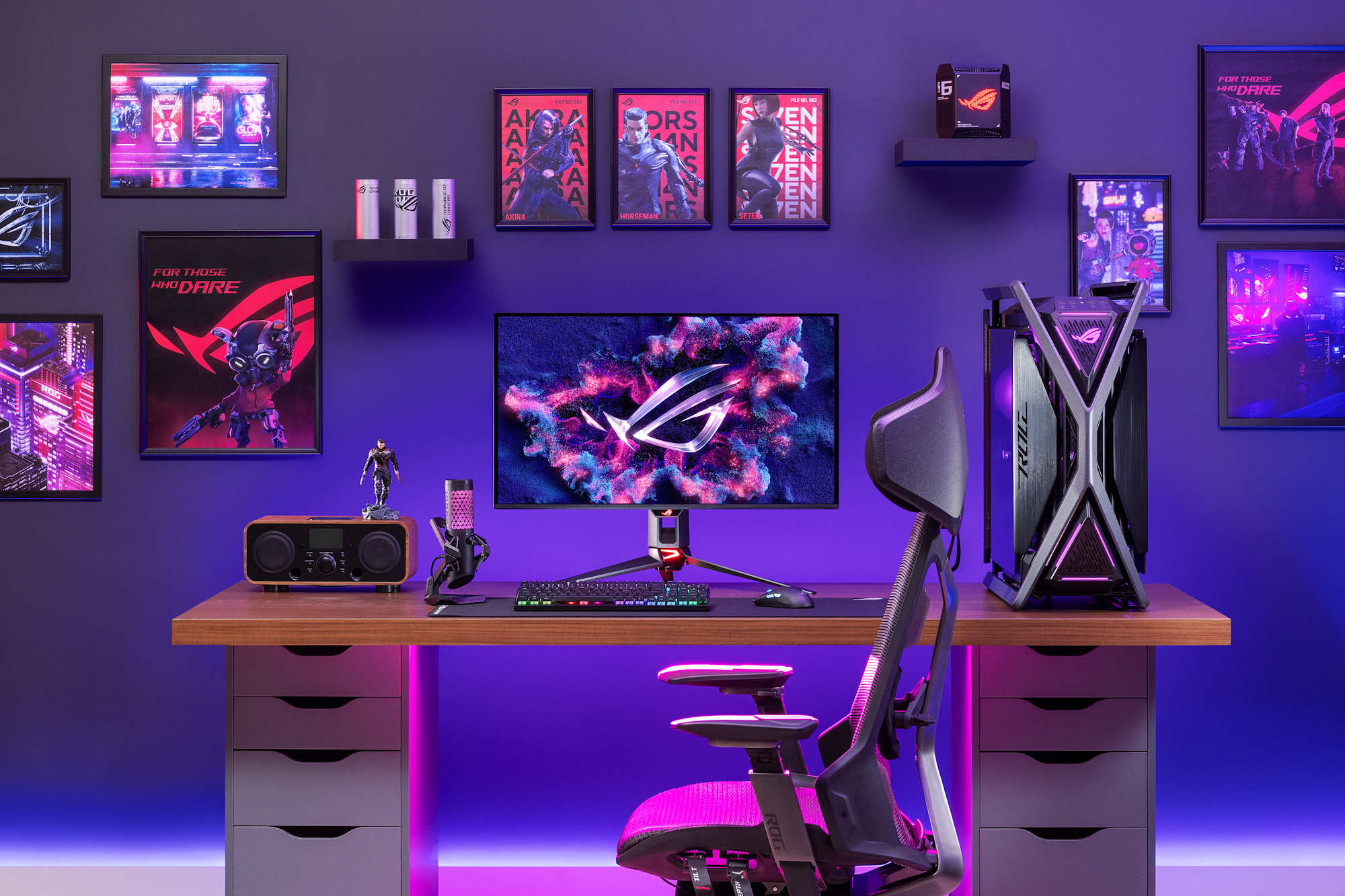 A collection of ROG gaming gear on a desk with an ROG OLED monitor at the center