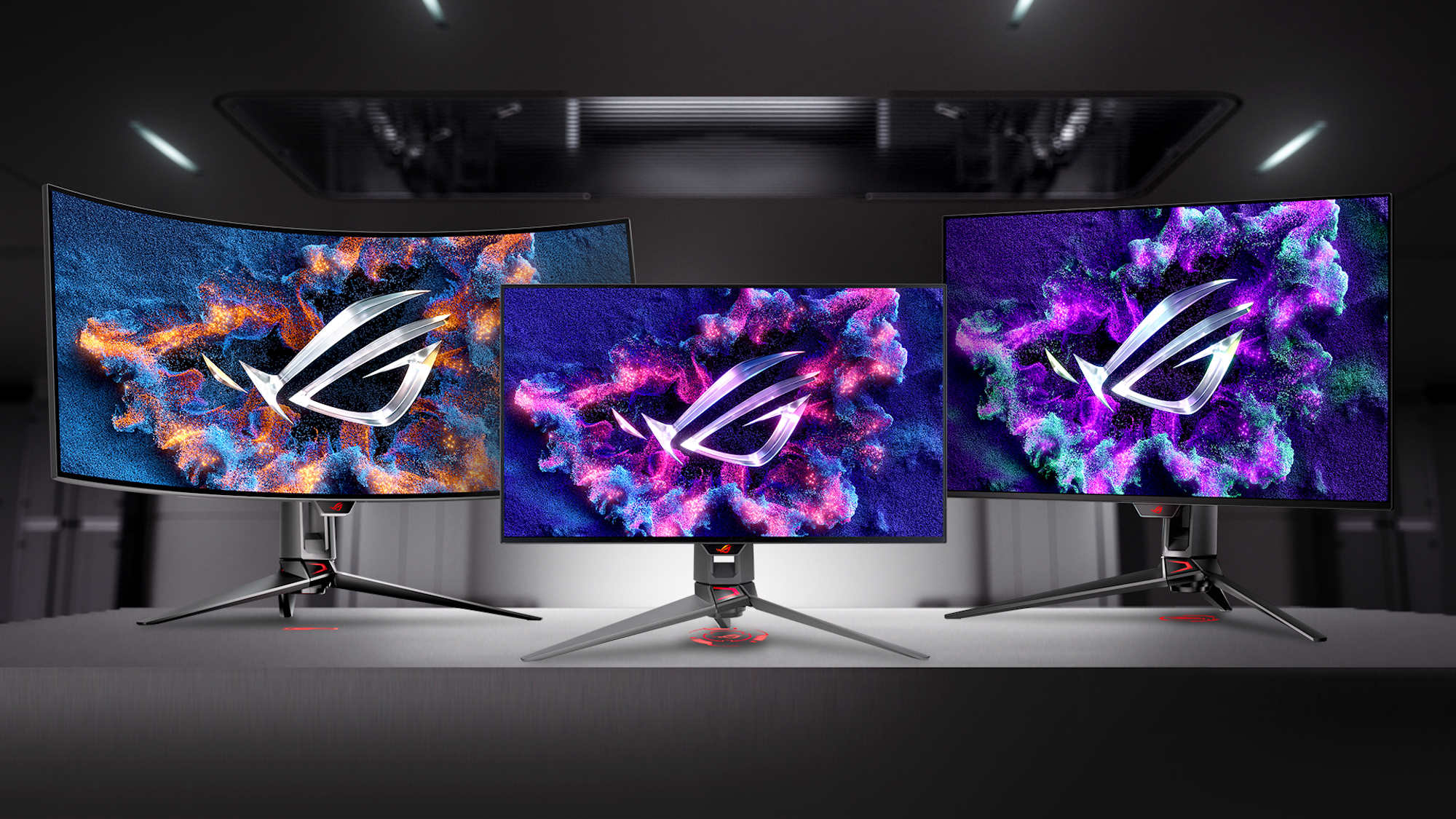 Three ROG OLED monitors arranged on a table against a sci-fi background