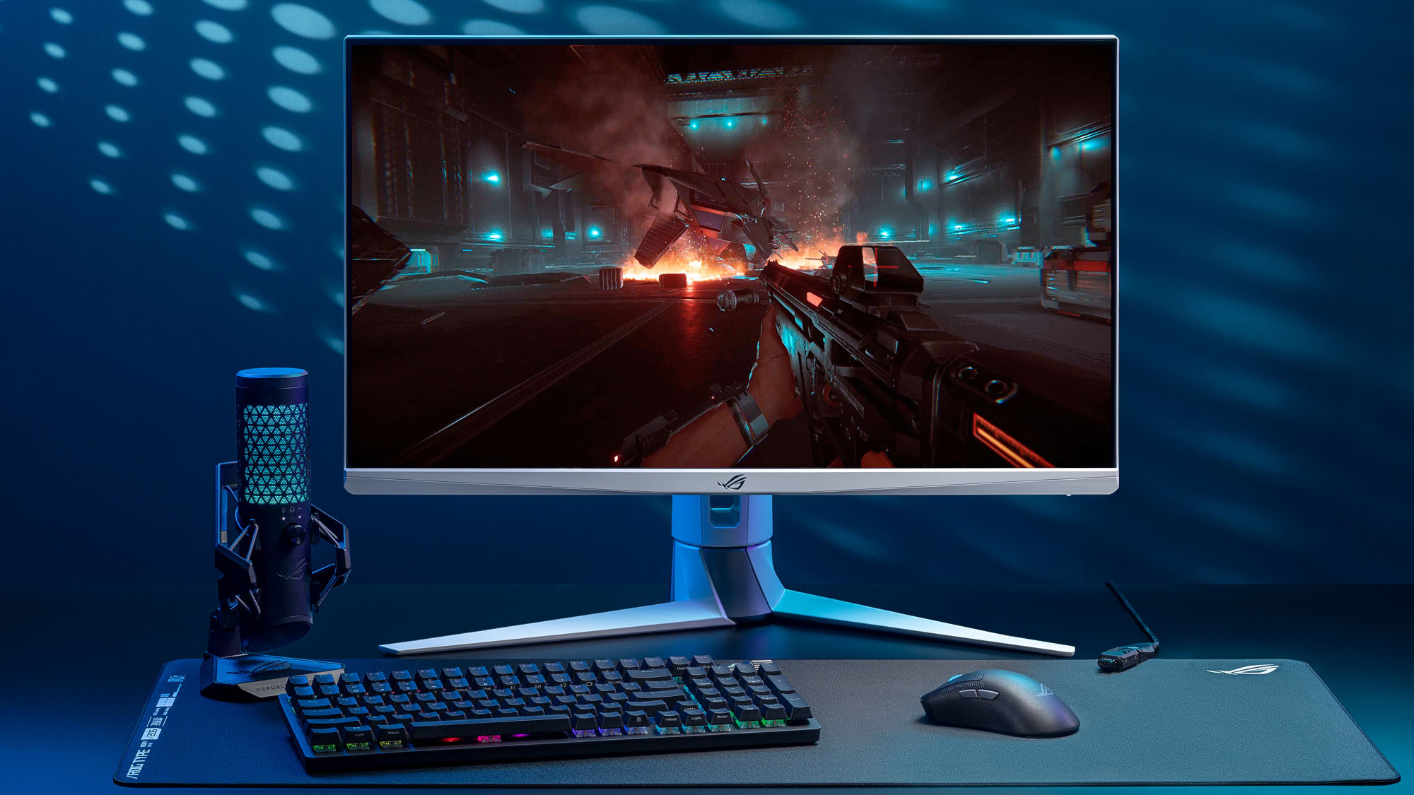 A gaming setup showing a monitor, keyboard, mouse, and microphone.