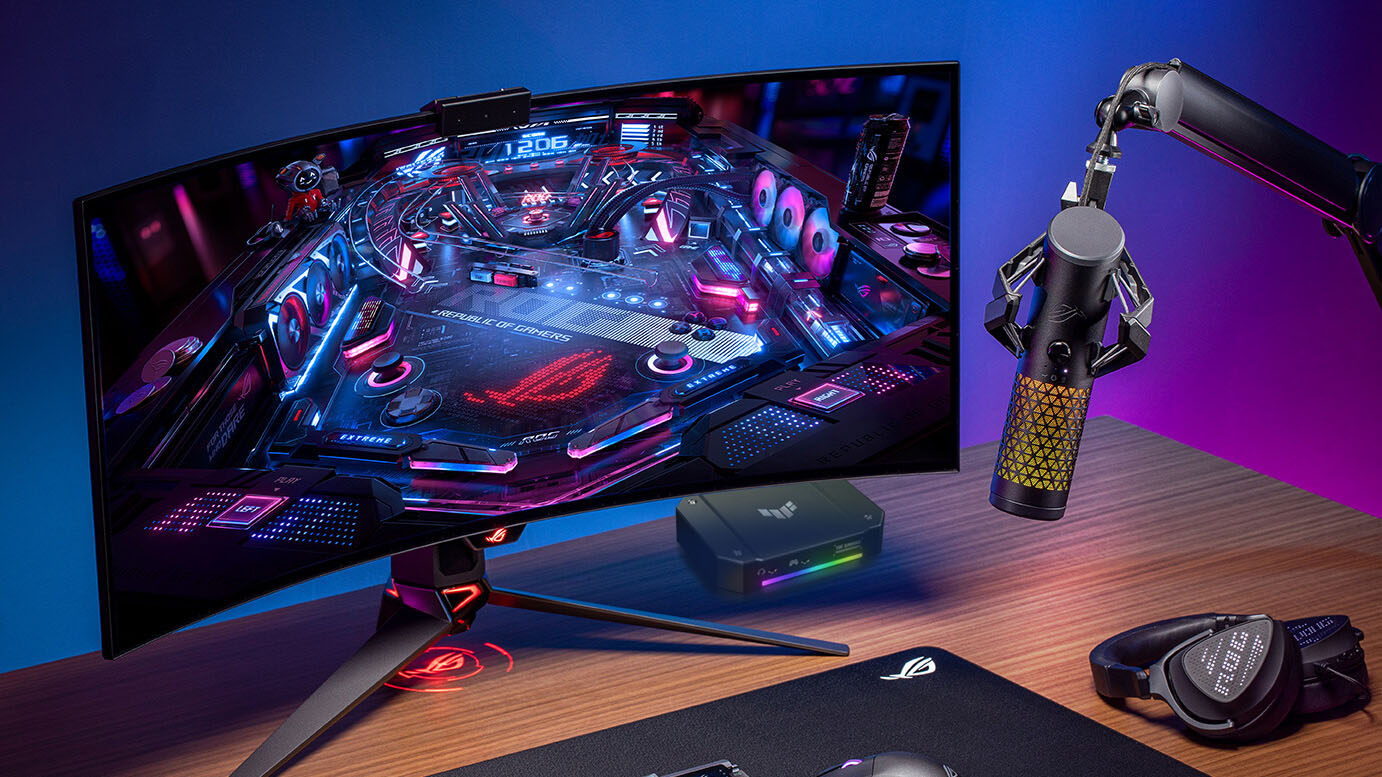 A desktop computer with a headset and microphone next to the monitor.