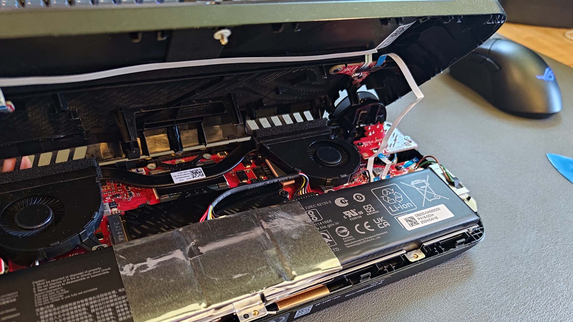The inside of the ROG Ally X, with a white ribbon cable connecting the two panels.