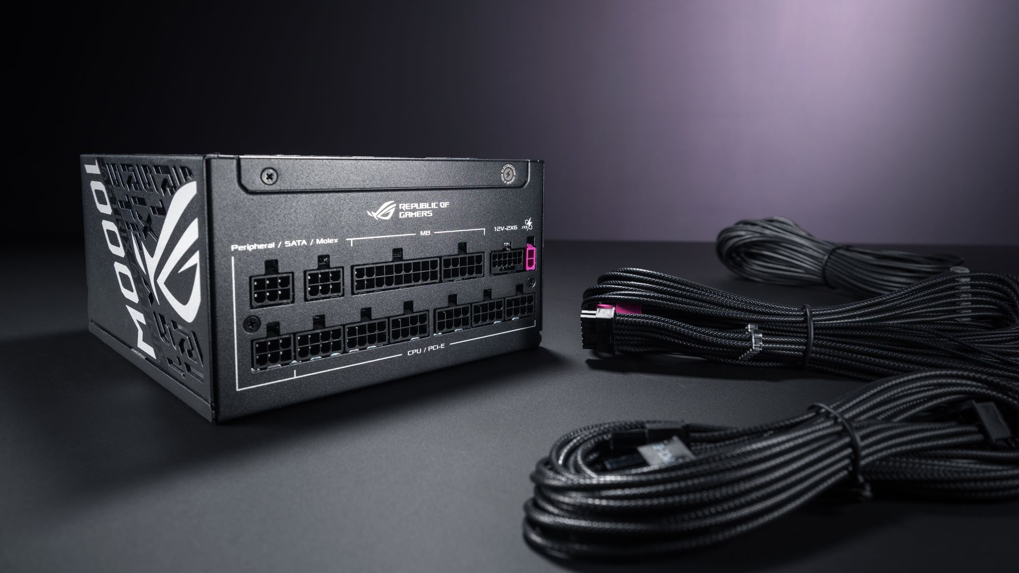 The ROG Strix Platinum 1000W PSU alongside cables against a gray backdrop