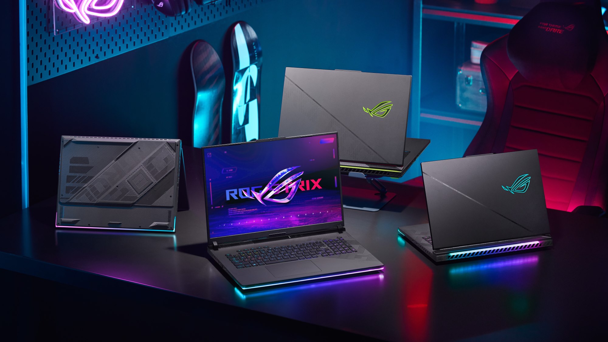 The 2024 Strix SCAR and Strix G laptop families on a table in a dark gaming room.