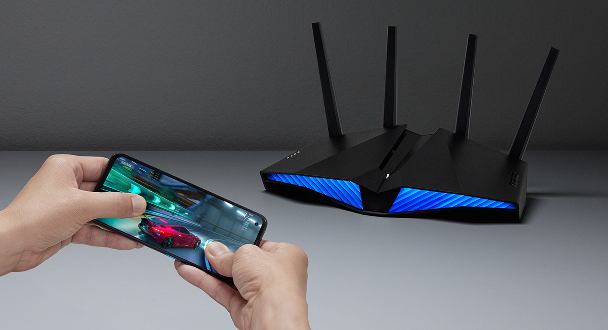 A person gaming on a mobile device with an ASUS RT-AX82U wireless router in the background