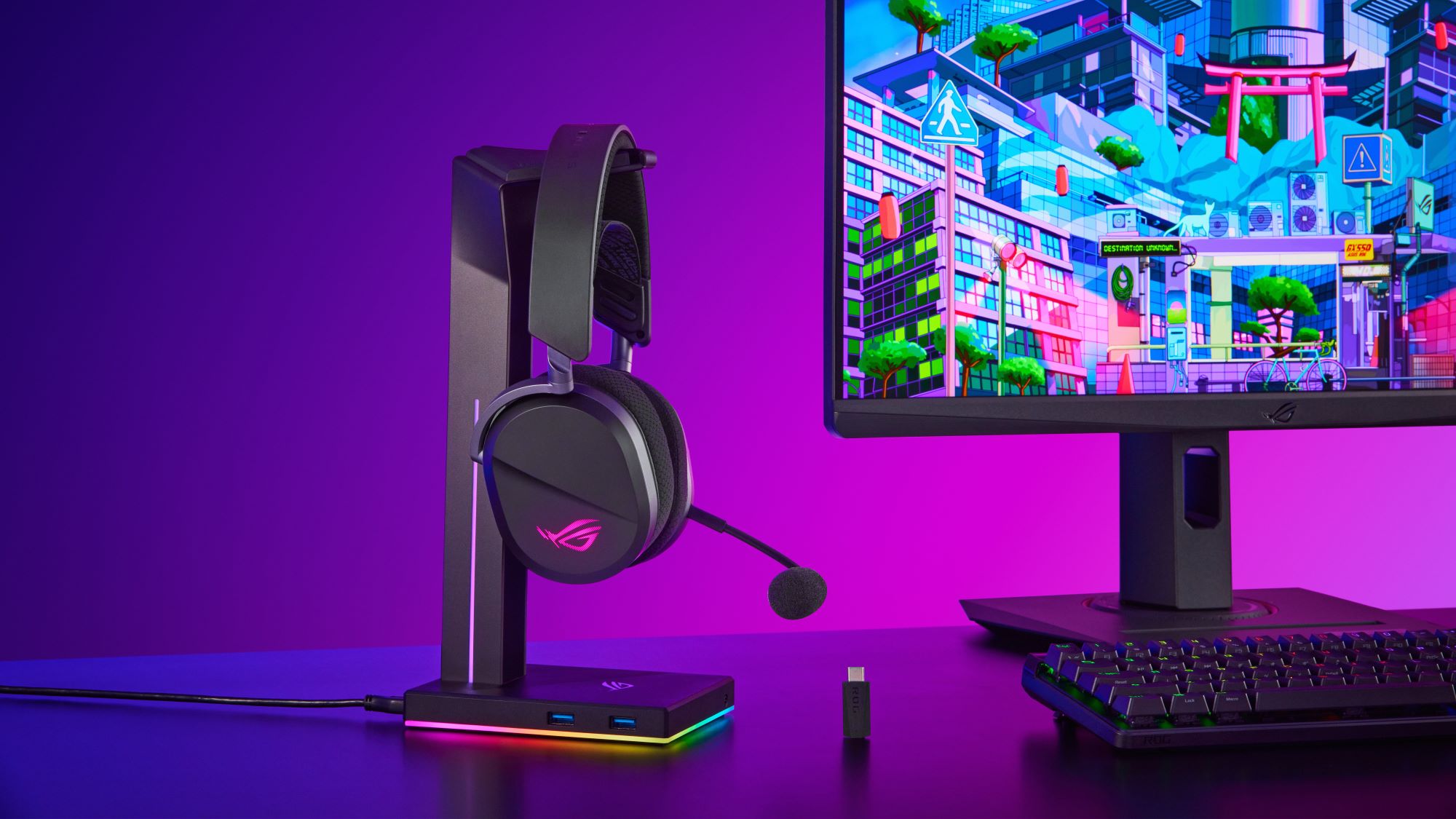 ROG Pelta gaming headset hanging from a stand beside a monitor on a gaming desk