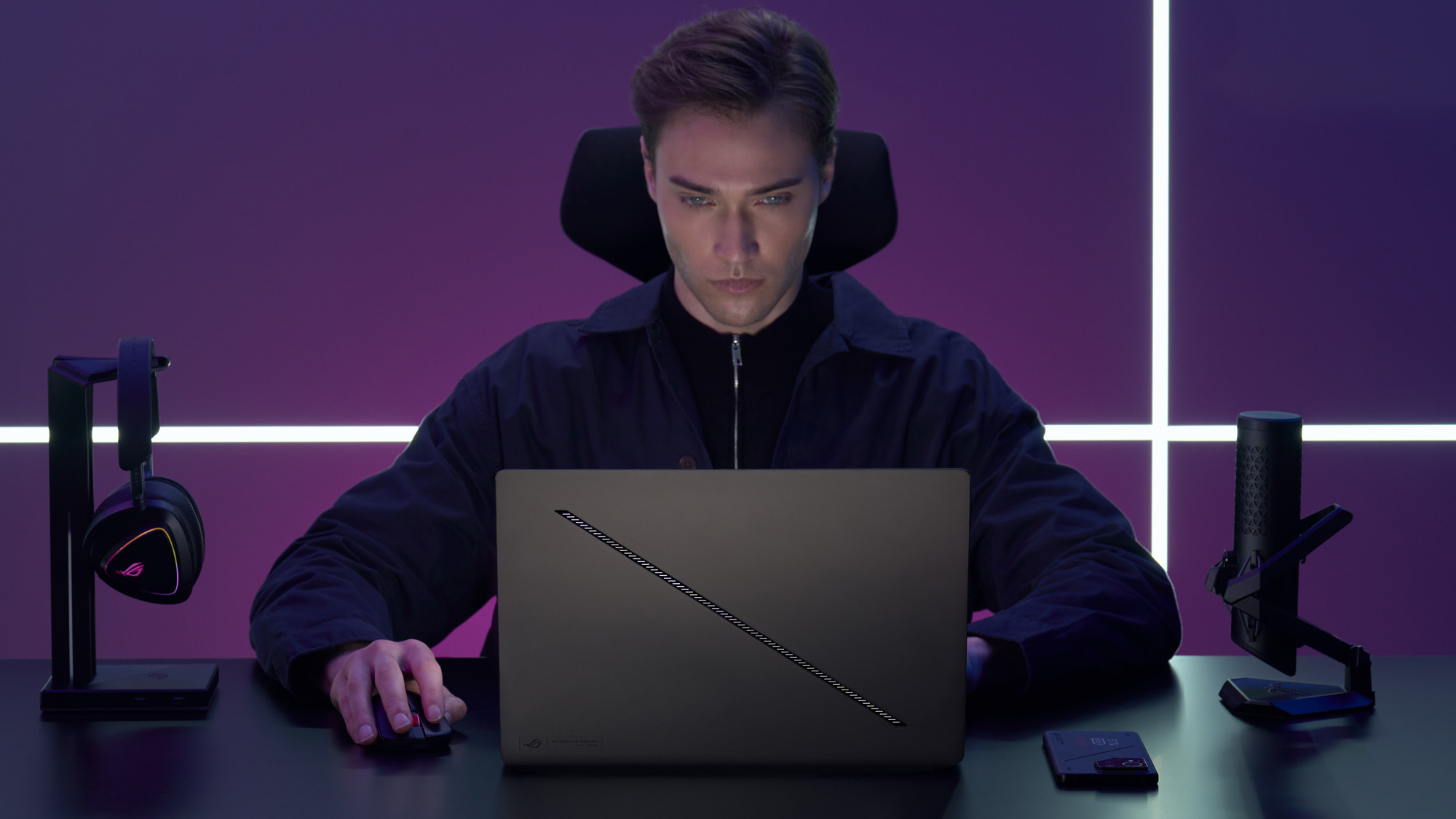 A man using a Zephyrus G16 on a black desk.