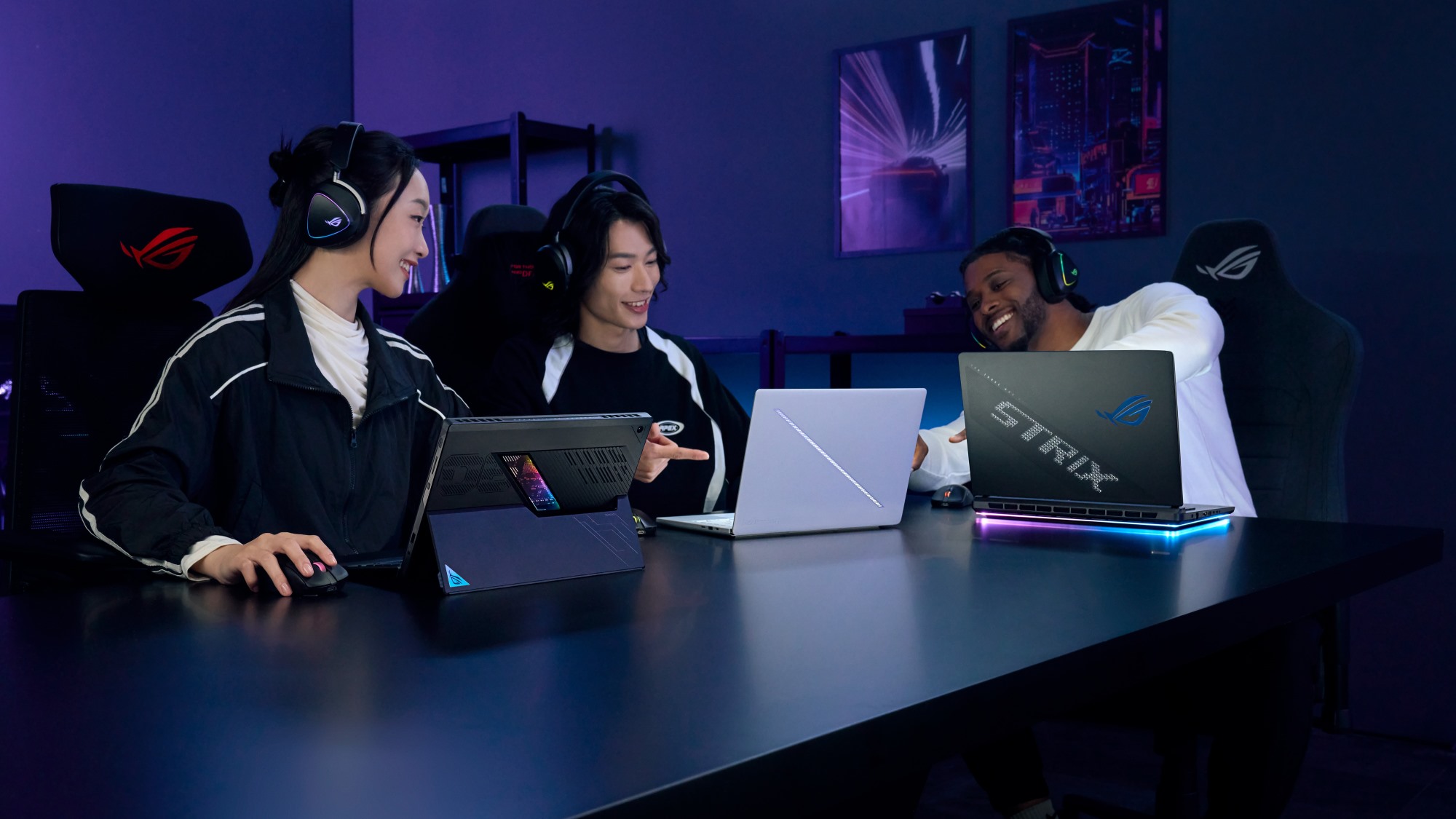 Three people playing games on ROG laptops.