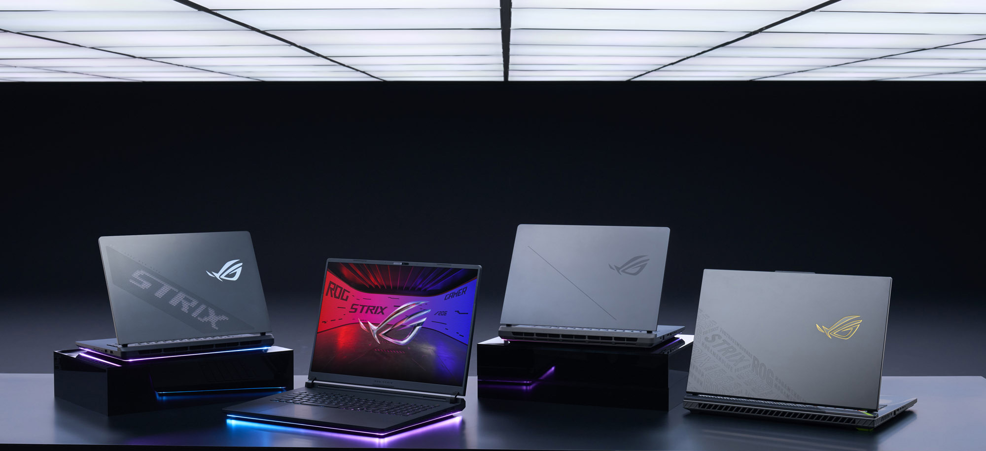 The-2025-Strix-laptop-lineup-on-a-table-in-a-dark-room_
