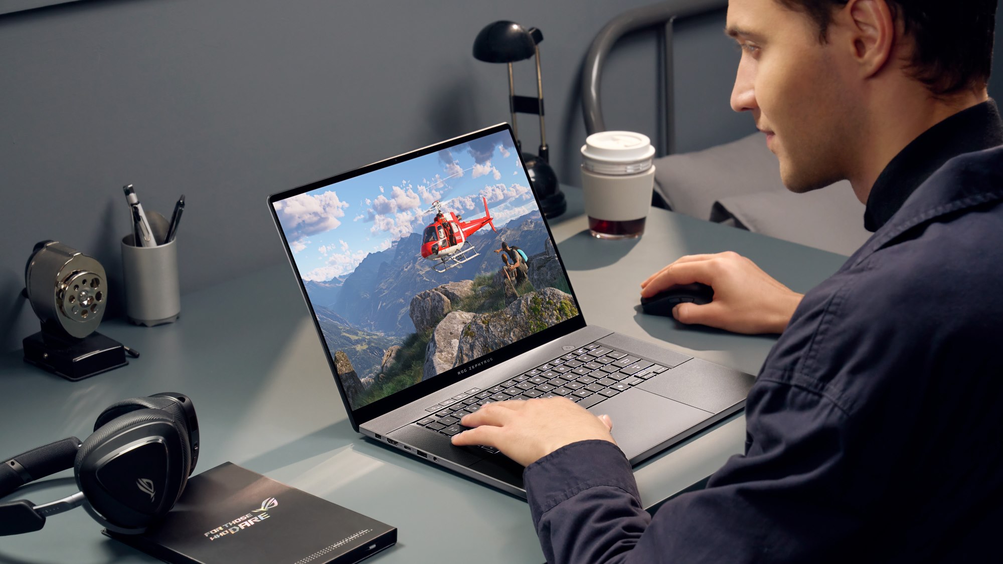 A man playing games on a Zephyrus G14 lapttop in a dorm room