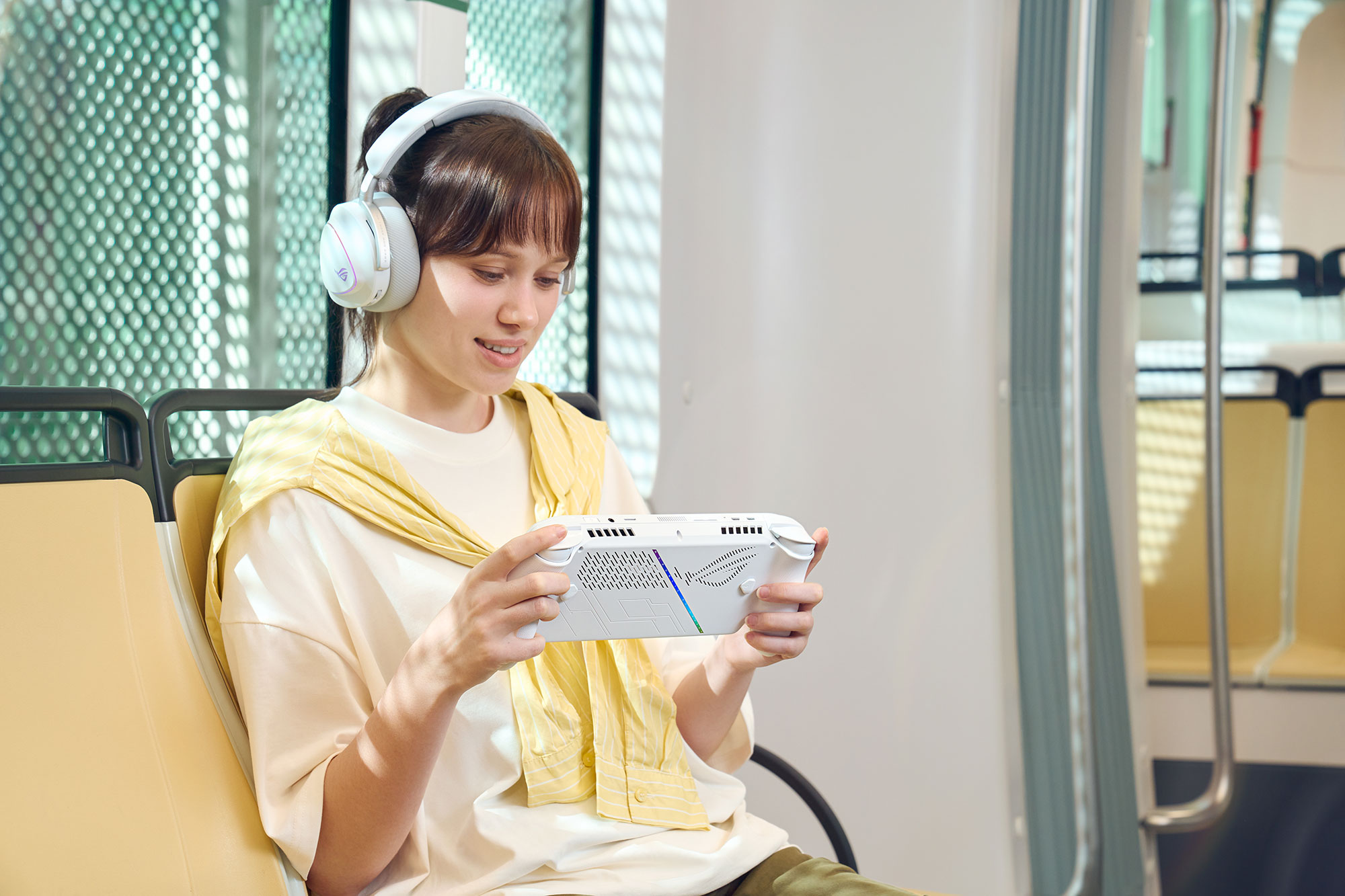 A woman holding the ROG Xbox Ally in her hands, with the Xbox app visible on screen.