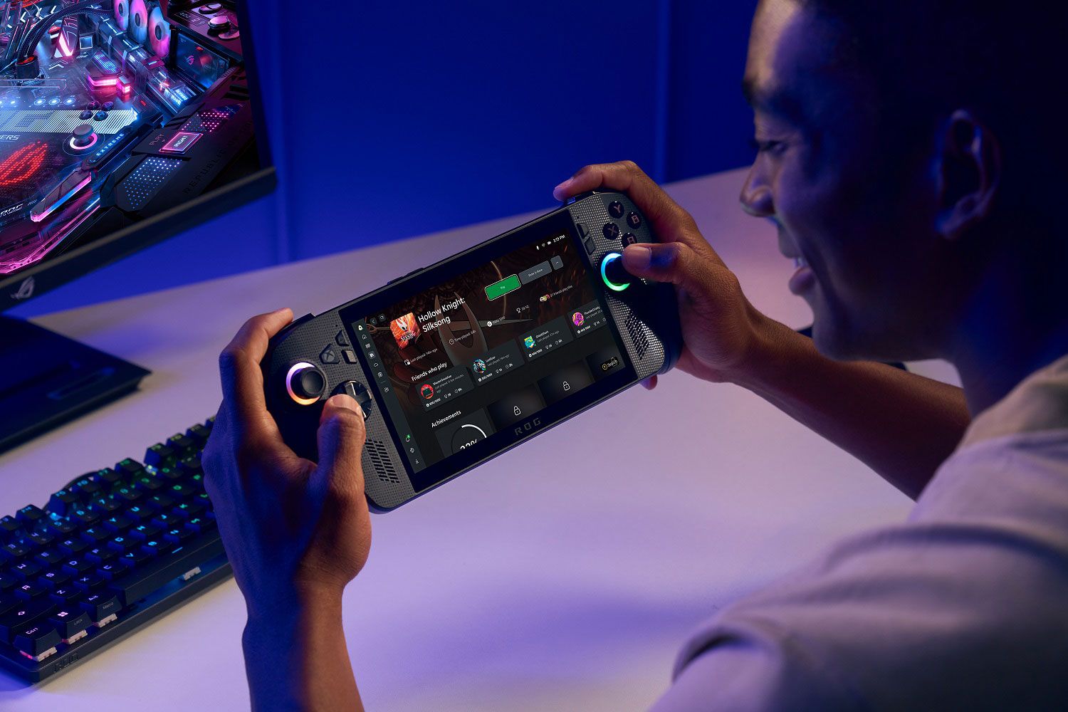 A man smiling and holding the ROG Xbox Ally X, with the rear of the device visible.