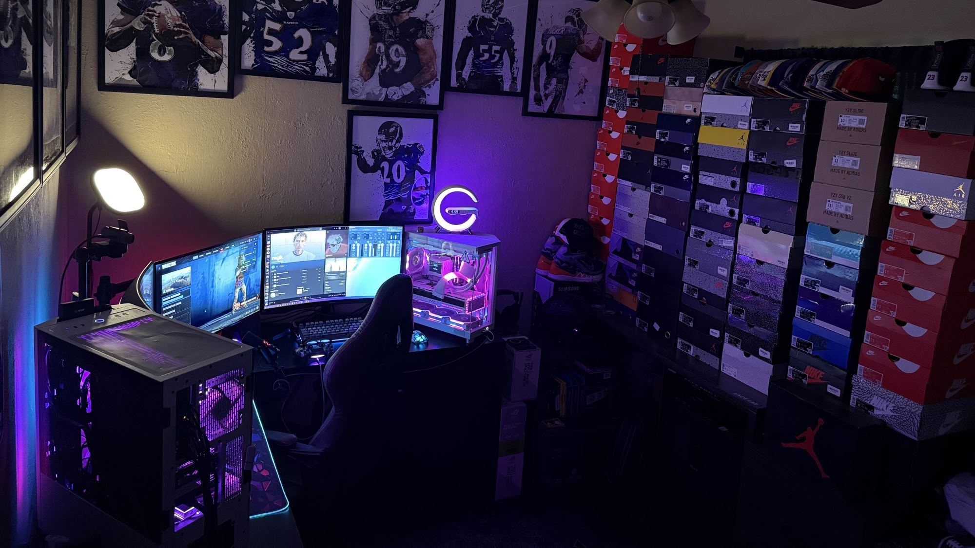 Discord user ItsYaBoyAtown's PC setup featuring two desktops, three monitors, and a lot of framed football player posters.