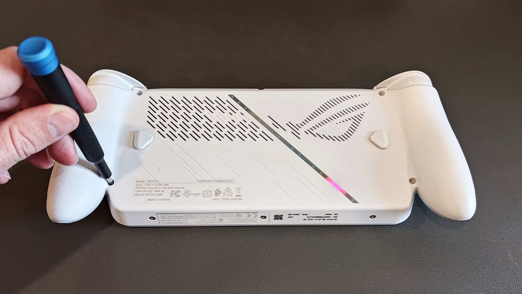 The ROG Xbox Ally face-down on a table with a screwdriver