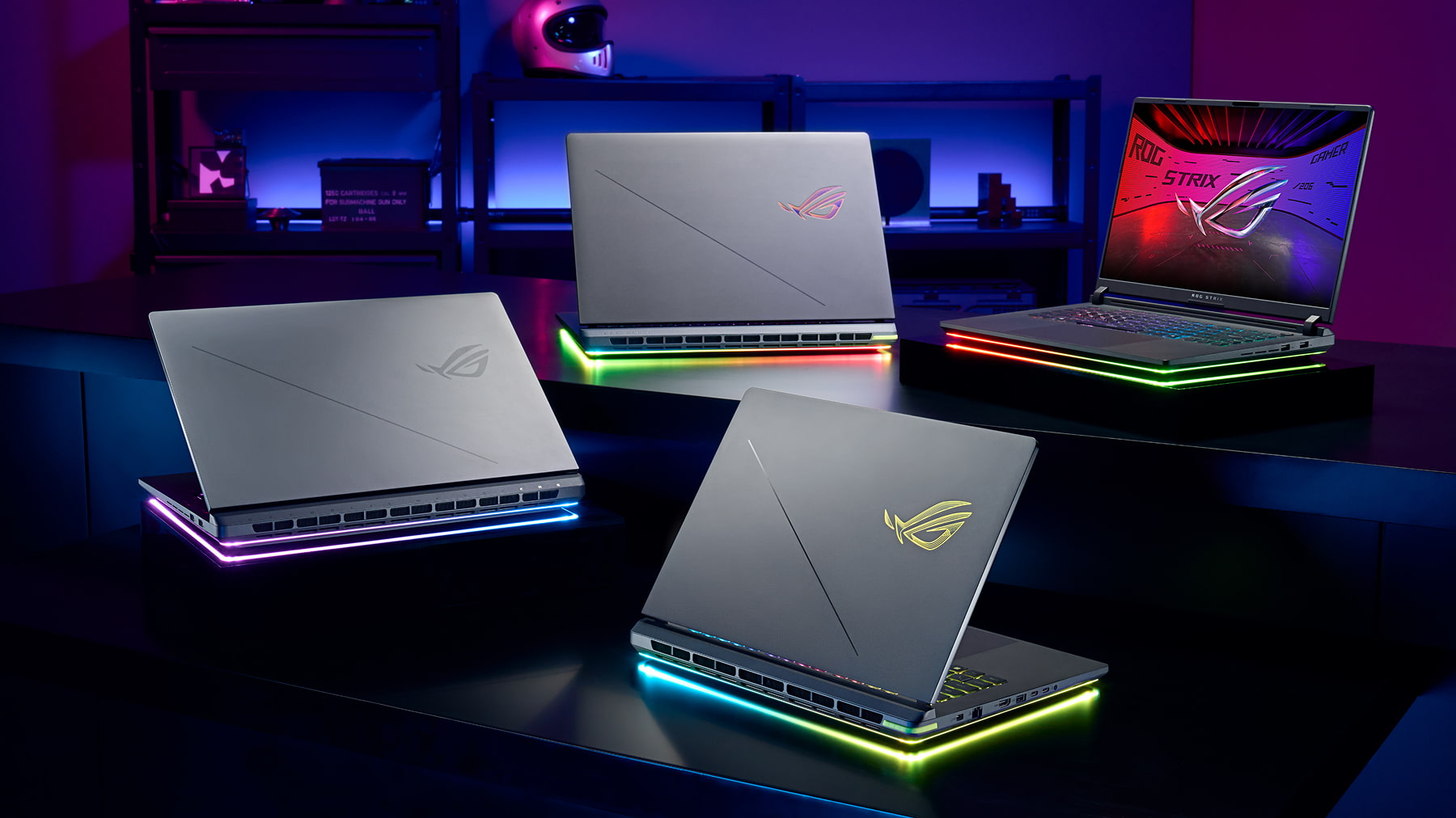 Quatro notebooks gamer ROG Strix G16 e G18 exibidos em ambiente futurista com iluminação RGB vibrante na base e logotipos iluminados na tampa.