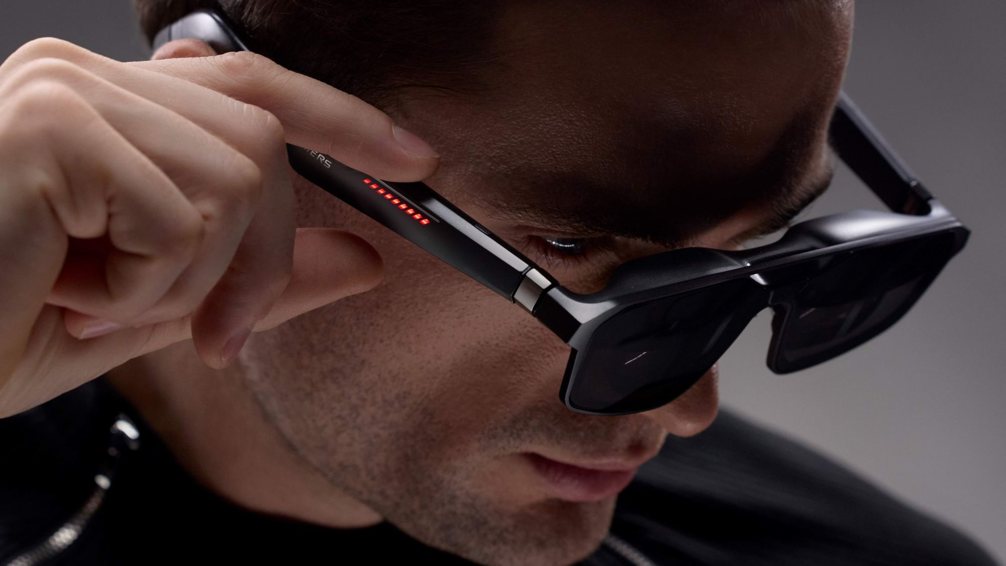 Nahaufnahme einer PErson, die die ROG XREAL R1 AR-Brille trägt und an die Bedienelemente fasst